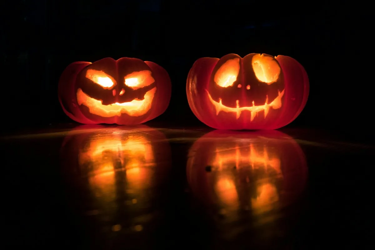 Carved jack o lantern pumpkins glowing at night