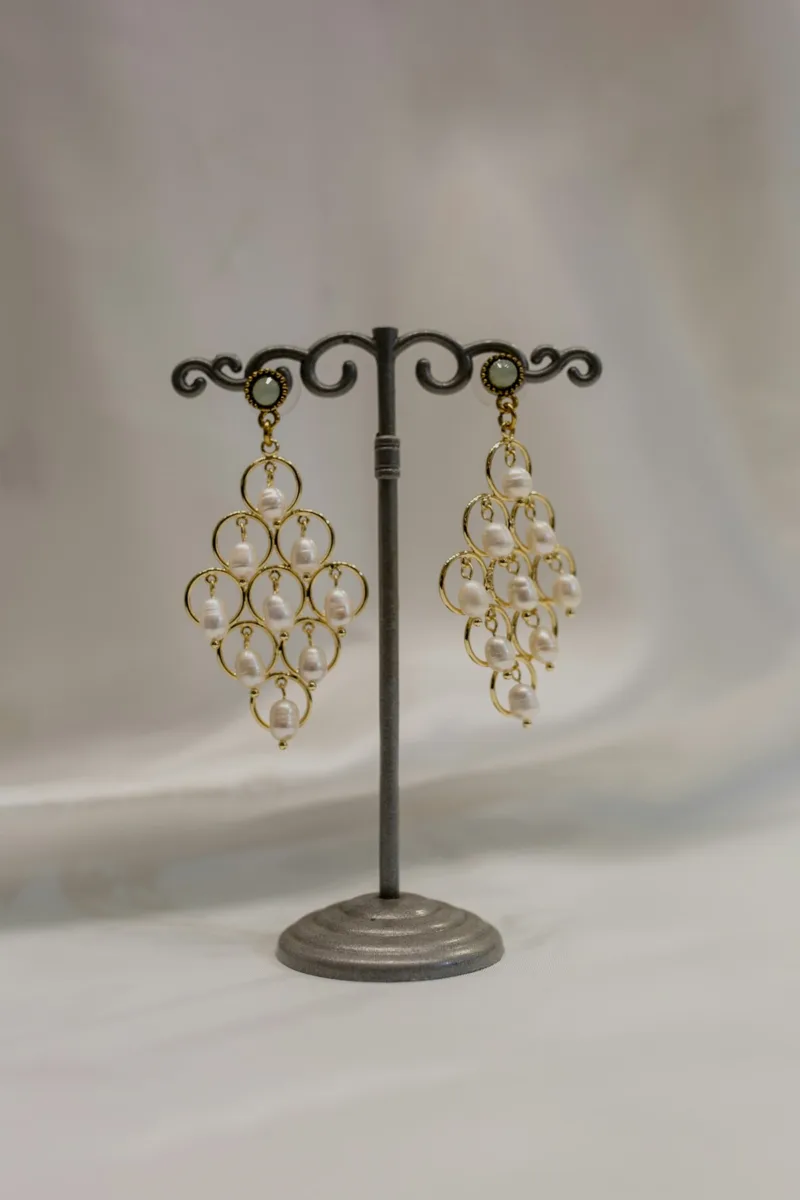 Chandelier earrings hanging on a stand