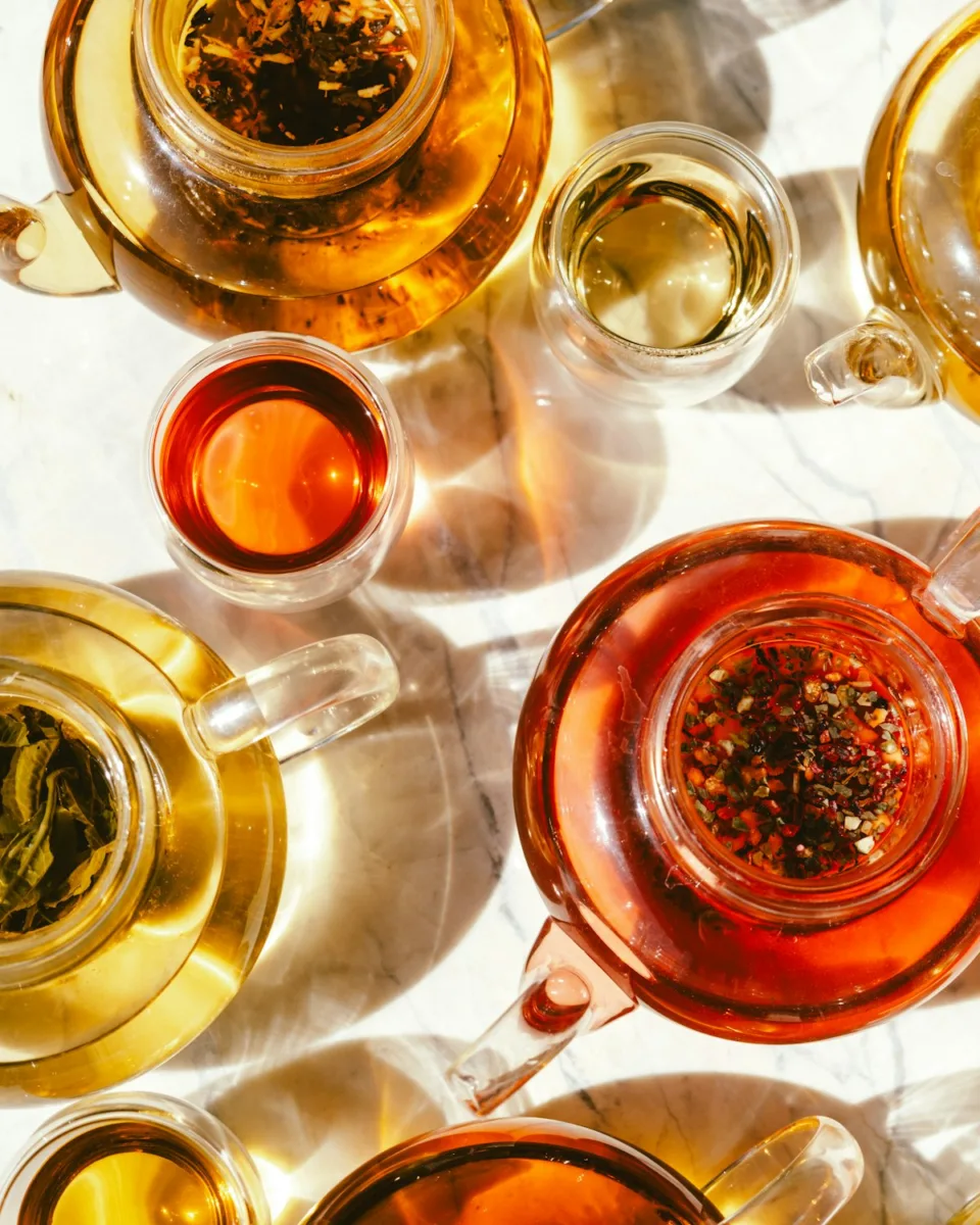Different types of tea in glass teapots and cups