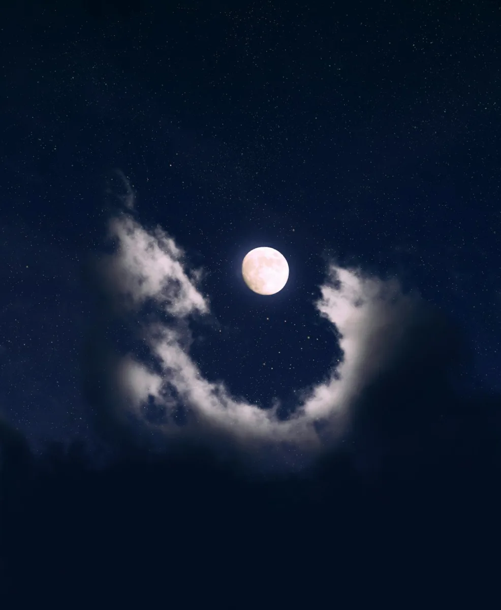 Full moon behind clouds at night