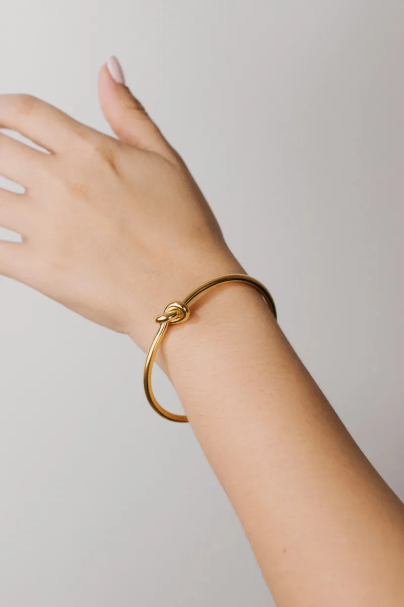 Gold cuff bracelet on a wrist