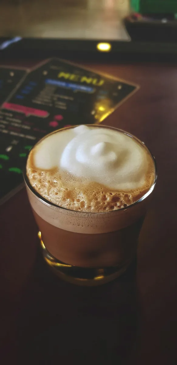 Macchiato coffee with foam in a glass cup