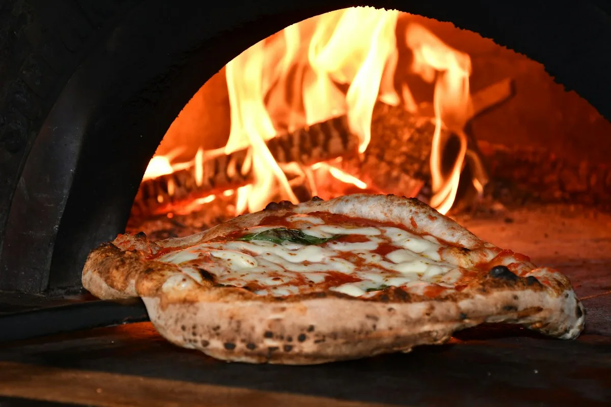 Neapolitan pizza baking in a wood fired oven