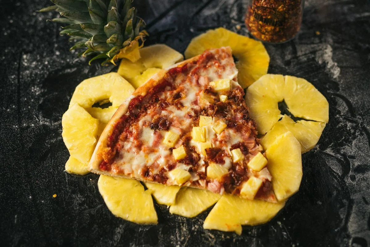 Slice of Hawaiian pizza with pineapple