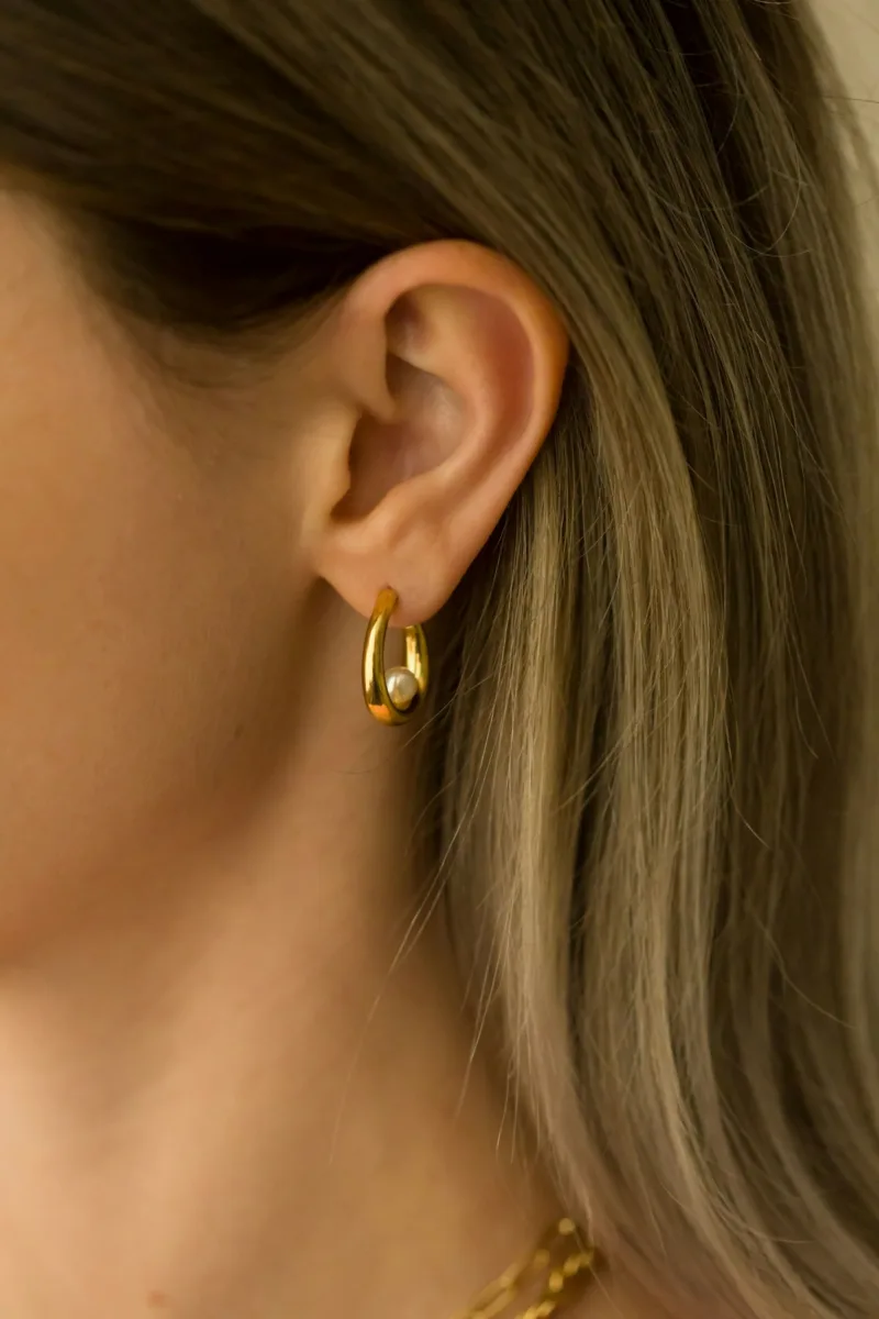 Small huggie hoop earring on an ear