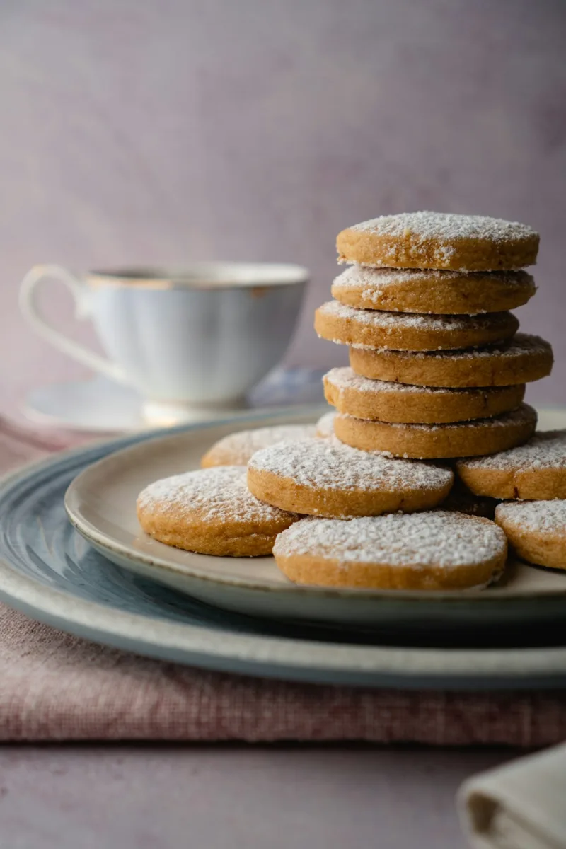 Stack of round shortbread cookies with a cup of tea