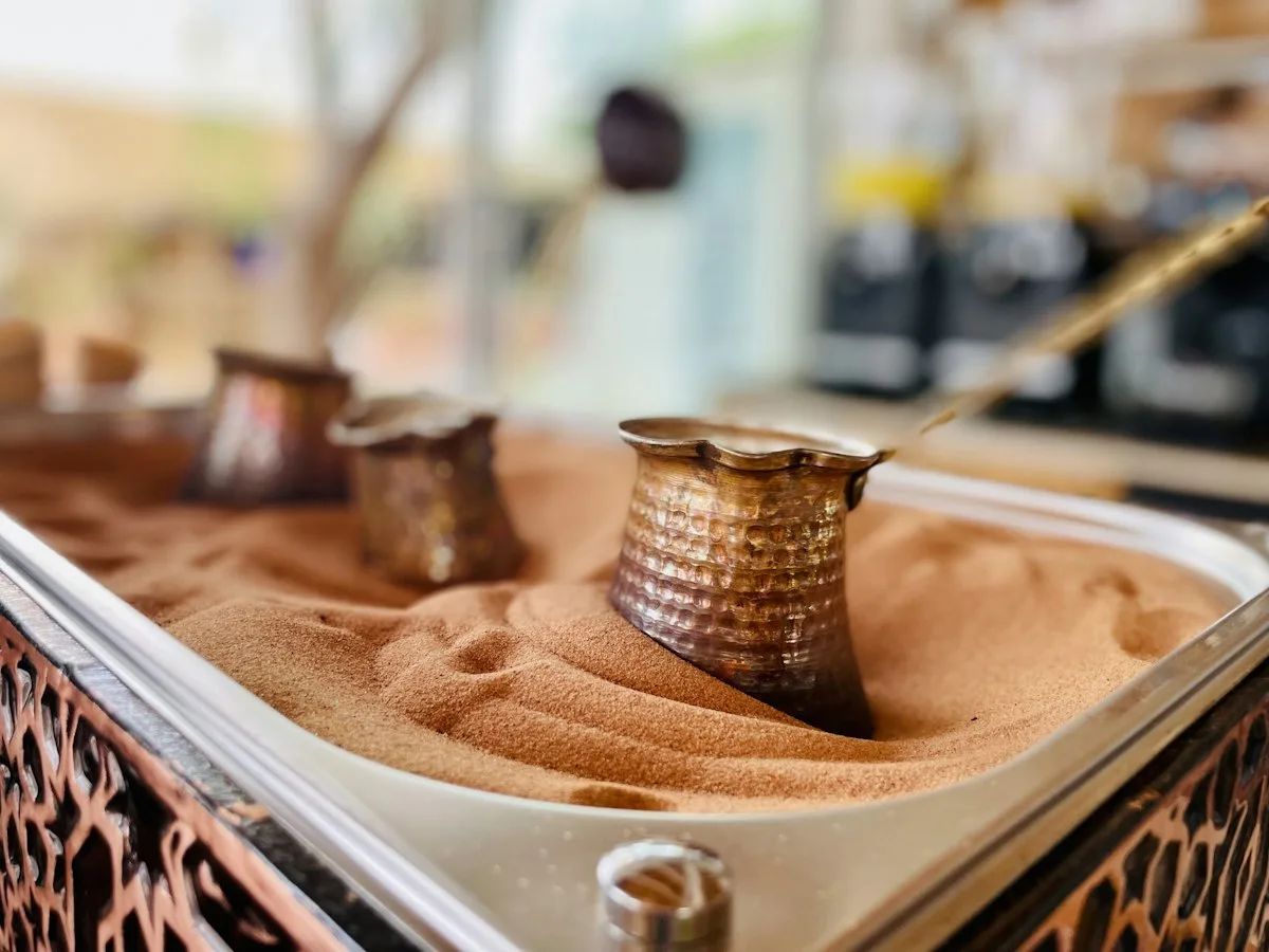 Turkish coffee brewed in a cezve pot on hot sand