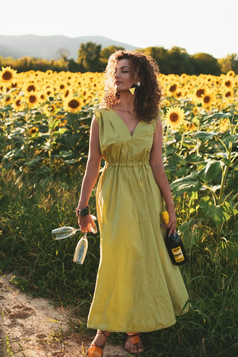 Woman in a yellow sundress in a sunflower field