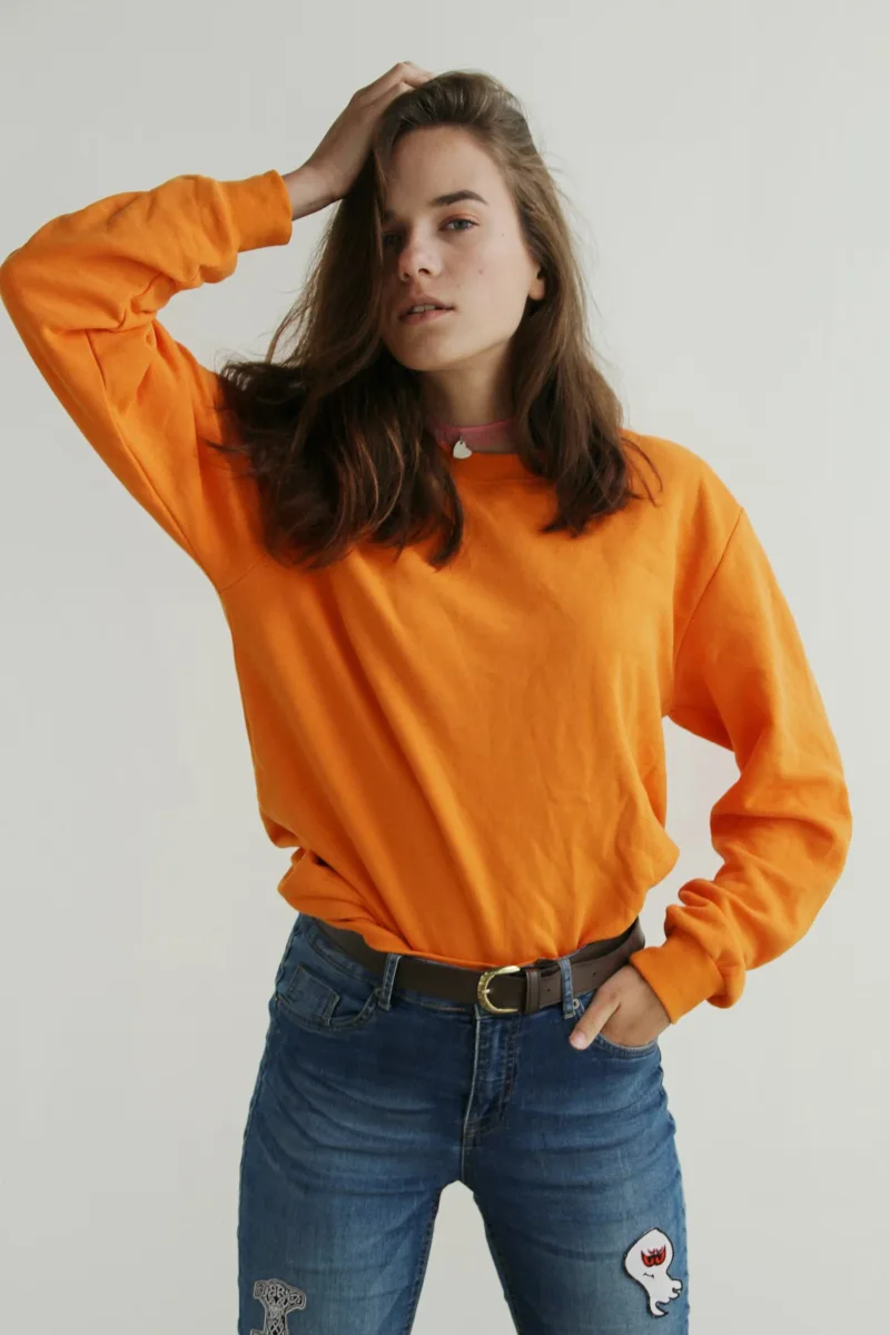 Woman wearing an orange crew neck sweater